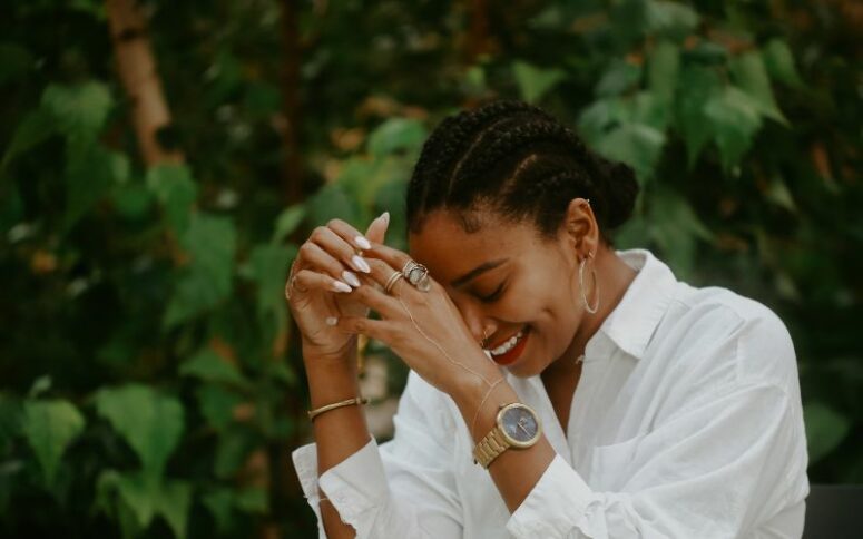 girl wearing white shirt and with cornrows hairstyle laughing protective hairstyle