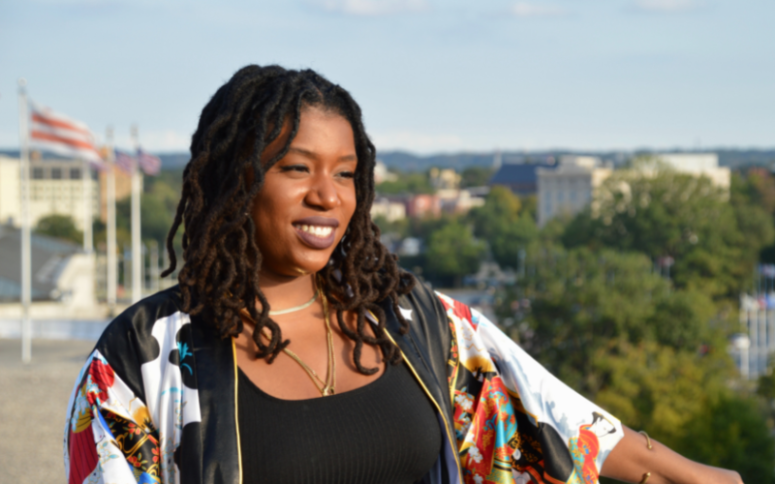A lady with dreadlocks overlooking a city