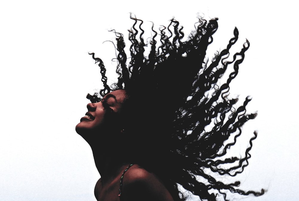 A lady throwing her long black hair back A lady throwing her long black hair back