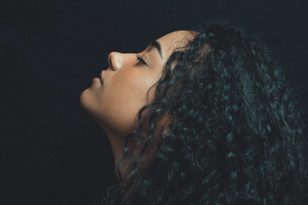 A lady with black curly hair looking up A lady with black curly hair looking up